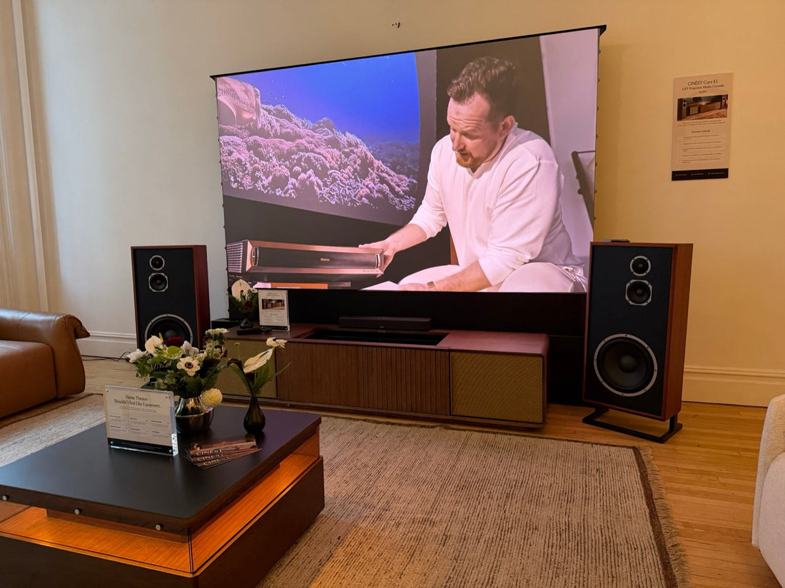 Wide view of the CINÈST NYC showcase living room featuring the Brown Core E1 motorized UST console, Hisense L9Q, 120-inch Spectra Projection Phoenix floor-rising UST ALR screen, and KLH Model Seven speakers.