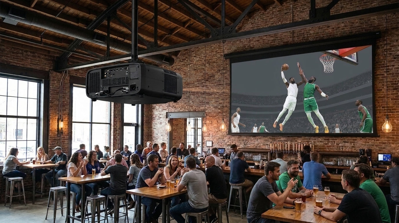 Upscale sports bar and taproom during an afternoon football broadcast with a ceiling-mounted commercial laser projector illuminating a 180-inch ALR screen under bar lights and window glare